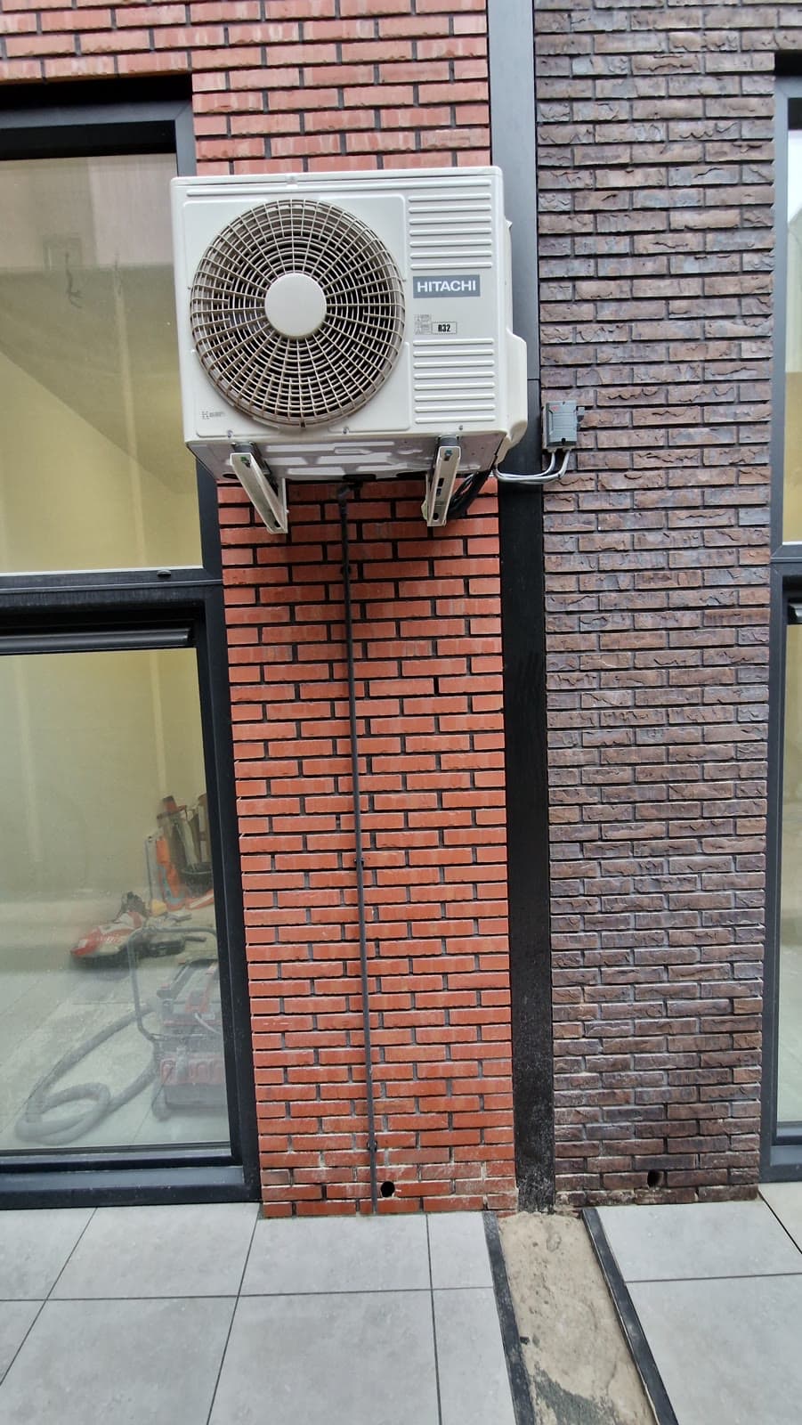 Hitachi buitenunit gemonteerd aan een bakstenen gevel